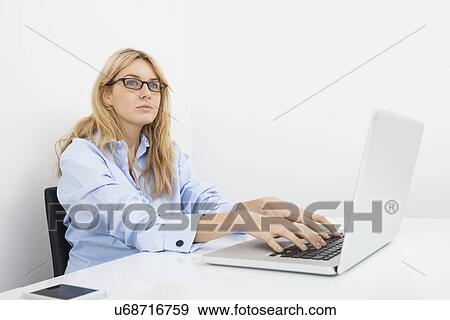Thoughtful businesswoman with laptop in office View Large Photo Image Stock Photo - Thoughtful businesswoman with laptop in office. Fotosearch