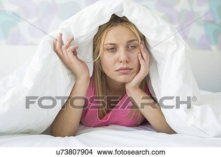 Thoughtful ill woman covered with quilt in bed View Large Photo Image Picture - Thoughtful ill woman covered with quilt in bed. Fotosearch