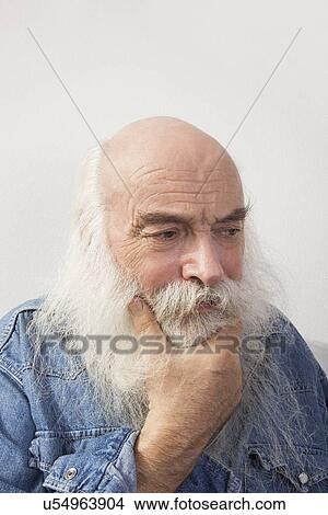 Thoughtful senior man looking down over gray background View Large Photo Image Picture - Thoughtful senior man looking down over gray background. Fotosearch