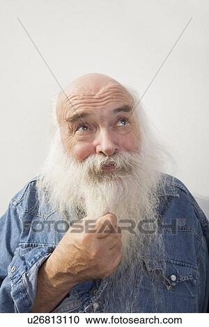 Thoughtful senior man looking up over gray background View Large Photo Image Stock Image - Thoughtful senior man looking up over gray background. Fotosearch