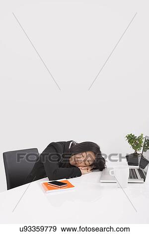 Stock Photo - Tired businesswoman resting at desk in office. Fotosearch