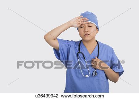 Tired female doctor with stethoscope around neck in hospital View Large Photo Image Stock Image - Tired female doctor with stethoscope around neck in hospital. Fotosearch