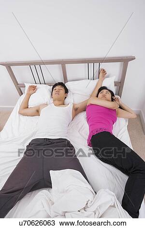 Uncomfortable woman sleeping by man in bed View Large Photo Image Stock Image - Uncomfortable woman sleeping by man in bed. Fotosearch