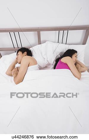 Unhappy Asian couple sleeping back to back in bed View Large Photo Image Stock Photograph - Unhappy Asian couple sleeping back to back in bed. Fotosearch