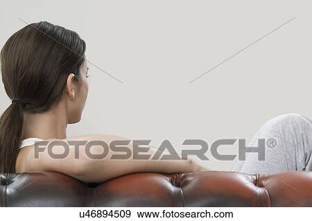 Stock Photo - Woman on sofa over gray background. Fotosearch
