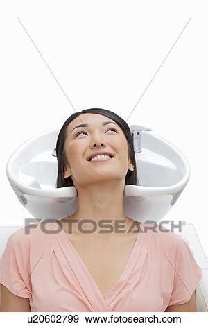 Stock Photo - Woman resting head in sink against white background. Fotosearch