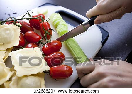 Woman's hand chopping cucumber at kitchen counter View Large Photo Image Stock Photo - Woman's hand chopping cucumber at kitchen counter. Fotosearch