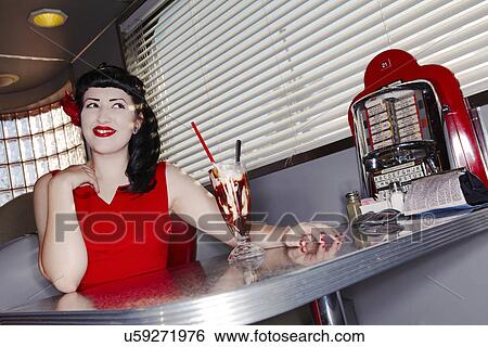 Young beautiful woman in red dress with chocolate smoothie at restaurant table View Large Photo Image Stock Photograph - Young beautiful woman in red dress with chocolate smoothie at restaurant table. Fotosearch