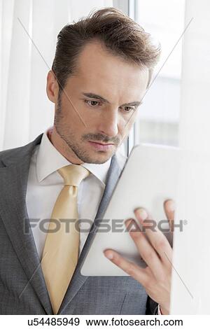 Stock Photo - Young businessman with digital tablet in office. Fotosearch
