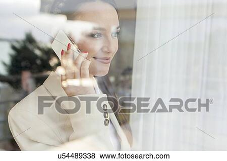 Young businesswoman using cell phone in office View Large Photo Image Stock Photo - Young businesswoman using cell phone in office. Fotosearch