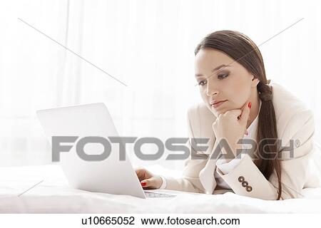 Young businesswoman using laptop in hotel room View Large Photo Image Stock Image - Young businesswoman using laptop in hotel room. Fotosearch