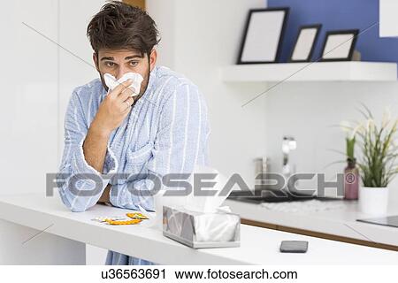 Young ill man blowing nose in tissue paper View Large Photo Image Stock Image - Young ill man blowing nose in tissue paper. Fotosearch