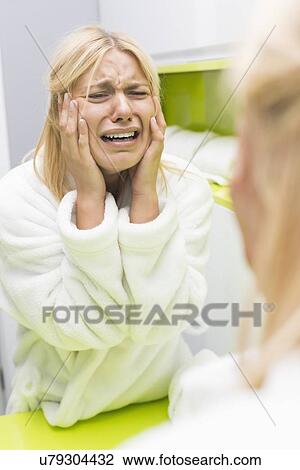 Young ill woman crying while looking at mirrior in bathroom View Large Photo Image Stock Image - Young ill woman crying while looking at mirrior in bathroom. Fotosearch
