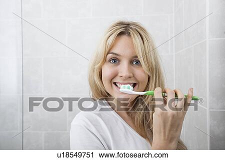 Young woman brushing teeth in bathroom View Large Photo Image Stock Image - Young woman brushing teeth in bathroom. Fotosearch