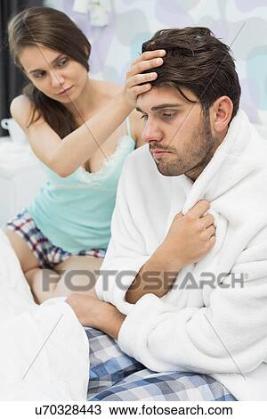 Young woman checking man's temperature on bed View Large Photo Image Stock Image - Young woman checking man's temperature on bed. Fotosearch