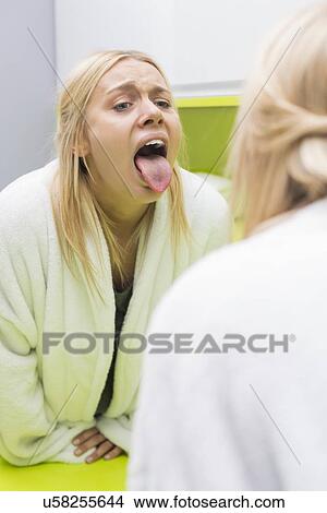 Young woman examining tongue in mirror View Large Photo Image Picture - Young woman examining tongue in mirror. Fotosearch