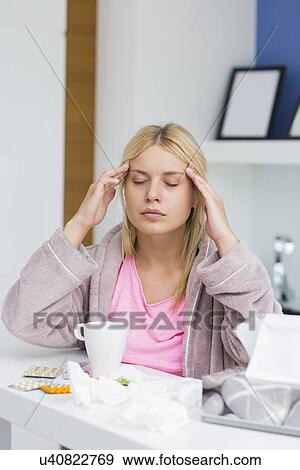 Young woman massaging head while suffering from cold View Large Photo Image Stock Photo - Young woman massaging head while suffering from cold. Fotosearch