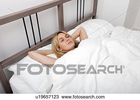 Young woman sleeping in bed View Large Photo Image Stock Image - Young woman sleeping in bed. Fotosearch