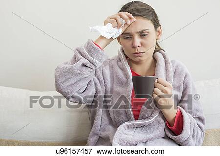 Young woman suffering from cold having coffee on bed View Large Photo Image Stock Photo - Young woman suffering from cold having coffee on bed. Fotosearch