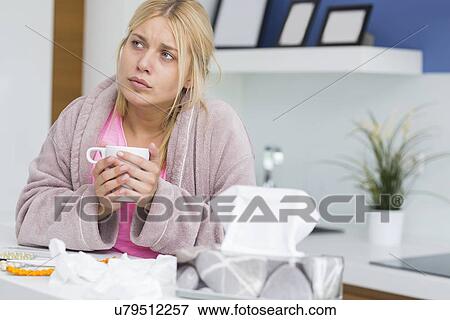 Young woman suffering from cold holding coffee mug View Large Photo Image Stock Photo - Young woman suffering from cold holding coffee mug. Fotosearch