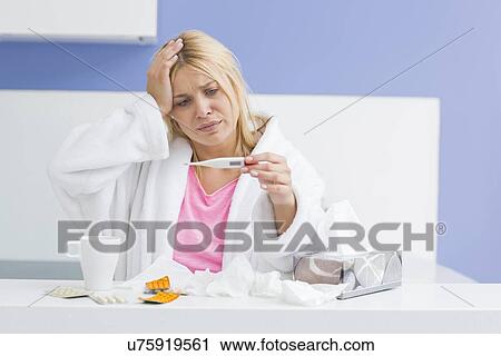 Young woman suffering from cold checking tempereature View Large Photo Image Stock Image - Young woman suffering from cold checking tempereature. Fotosearch