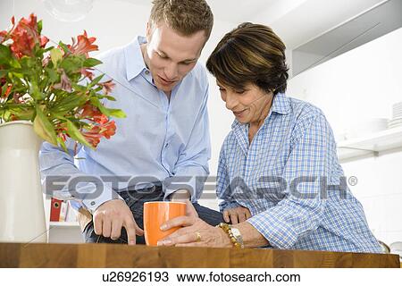 Adult grandson and grandmother in kitchen View Large Photo Image Stock Image - Adult grandson and grandmother in kitchen. Fotosearch