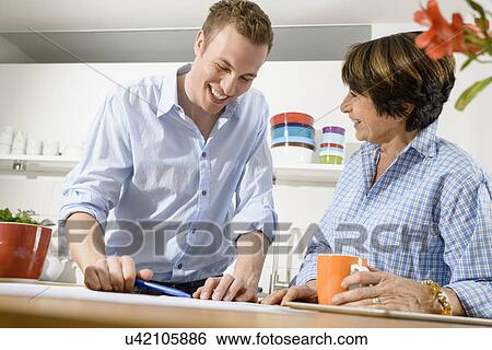 Adult grandson and grandmother looking at digital tablet View Large Photo Image Stock Photograph - Adult grandson and grandmother looking at digital tablet. Fotosearch