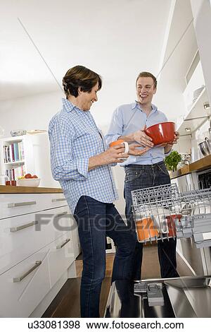 Stock Photo - Adult grandson helping grandmother in kitchen. Fotosearch