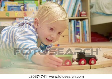 Baby boy playing with train set View Large Photo Image Stock Image - Baby boy playing with train set. Fotosearch