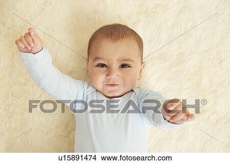 Baby lying on sheepskin rug View Large Photo Image Picture - Baby lying on sheepskin rug. Fotosearch