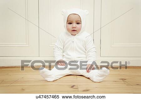 Baby sitting wearing bear babygro View Large Photo Image Stock Photography - Baby sitting wearing bear babygro. Fotosearch