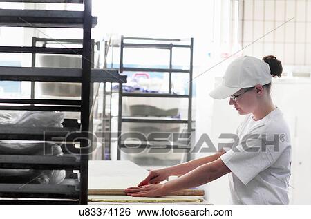 Stock Photograph - Baker cutting bread dough. Fotosearch