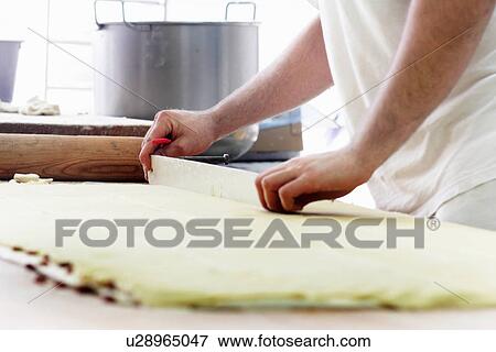 Baker cutting dough View Large Photo Image Stock Photo - Baker cutting dough. Fotosearch