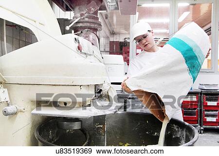 Stock Photo - Baker pouring flour into mixer. Fotosearch