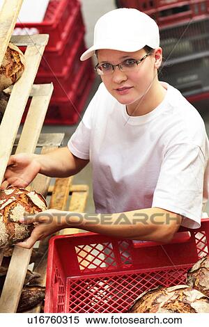 Stock Photography - Baker putting bread onto shelves. Fotosearch