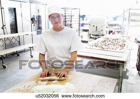 Stock Photograph - Baker rolling bread dough. Fotosearch