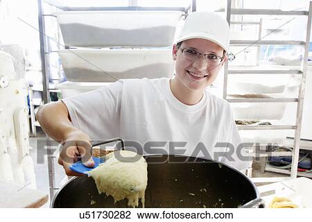 Baker scooping bread dough View Large Photo Image Stock Image - Baker scooping bread dough. Fotosearch