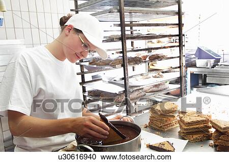 Stock Image - Baker stirring mixture. Fotosearch
