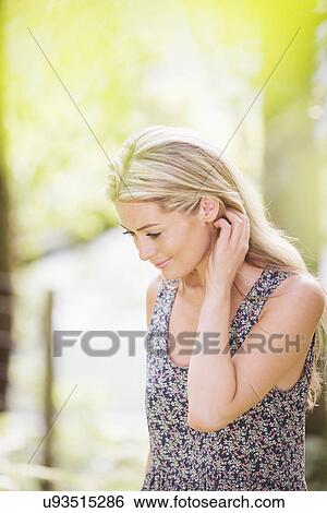 Stock Photograph - Blonde woman with hand in hair. Fotosearch