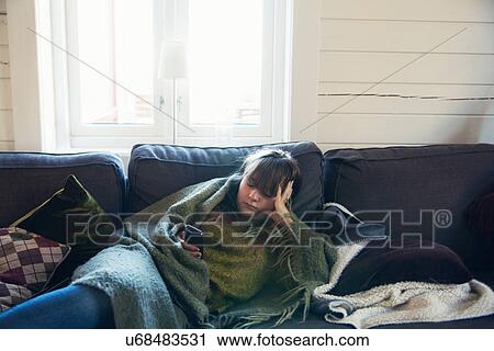 Bored teenage girl lounging on sofa looking at mobile phone View Large Photo Image Stock Image - Bored teenage girl lounging on sofa looking at mobile phone. Fotosearch