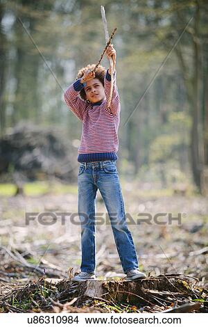 Boy aiming bow and arrow in woods View Large Photo Image Picture - Boy aiming bow and arrow in woods. Fotosearch