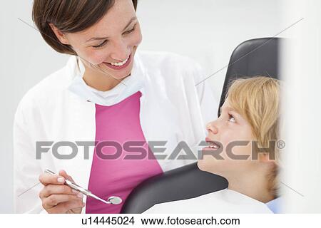Boy having check up, dentist holding dental mirror View Large Photo Image Picture - Boy having check up, dentist holding dental mirror. Fotosearch