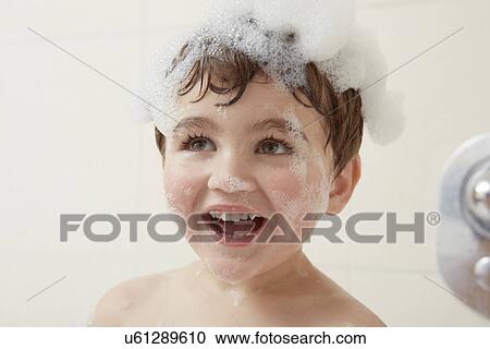 Stock Image - Boy in bath with bubbles on his head. Fotosearch
