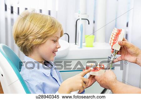 Boy in dentists chair learning how to brush teeth View Large Photo Image Stock Photography - Boy in dentists chair learning how to brush teeth. Fotosearch
