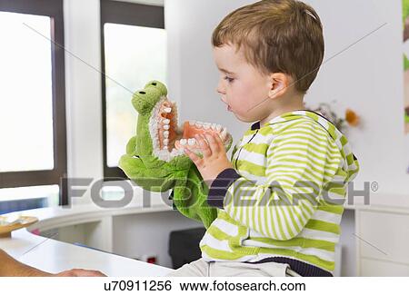 Stock Photograph - Boy playing with toy crocodile in dentists. Fotosearch