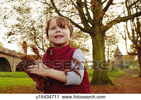 Boy throwing autumn leaves View Large Photo Image Stock Image - Boy throwing autumn leaves. Fotosearch