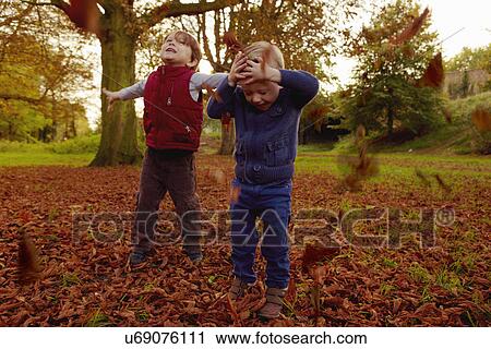 Boys throwing autumn leaves View Large Photo Image Stock Image - Boys throwing autumn leaves. Fotosearch