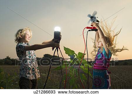 Stock Image - Brother and sister generating light from wind power, Zeeland, Netherlands. Fotosearch