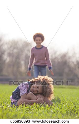 Brother and sister playing together in field View Large Photo Image Stock Image - Brother and sister playing together in field. Fotosearch
