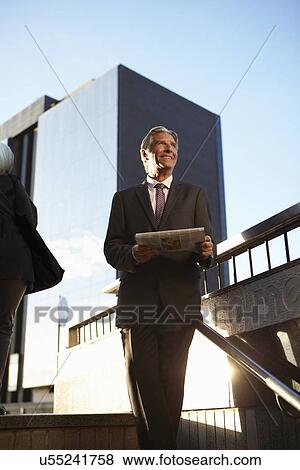 Businessman holding newspaper View Large Photo Image Stock Photo - Businessman holding newspaper. Fotosearch